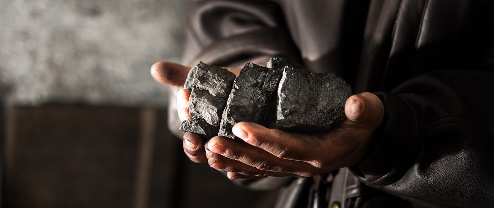 černé uhlí v ruce